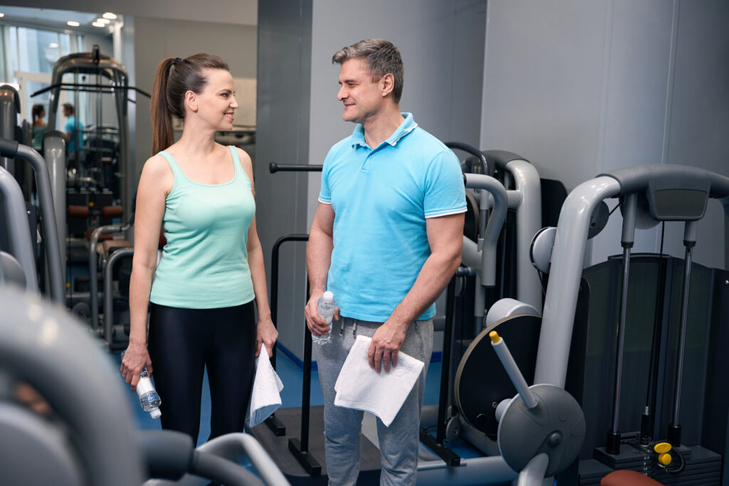 Gym equipment inspections support safe workouts as a trainer assists a member using professionally maintained fitness equipment.